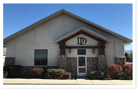 The outside of Doman Dental with flowers and shrubs.